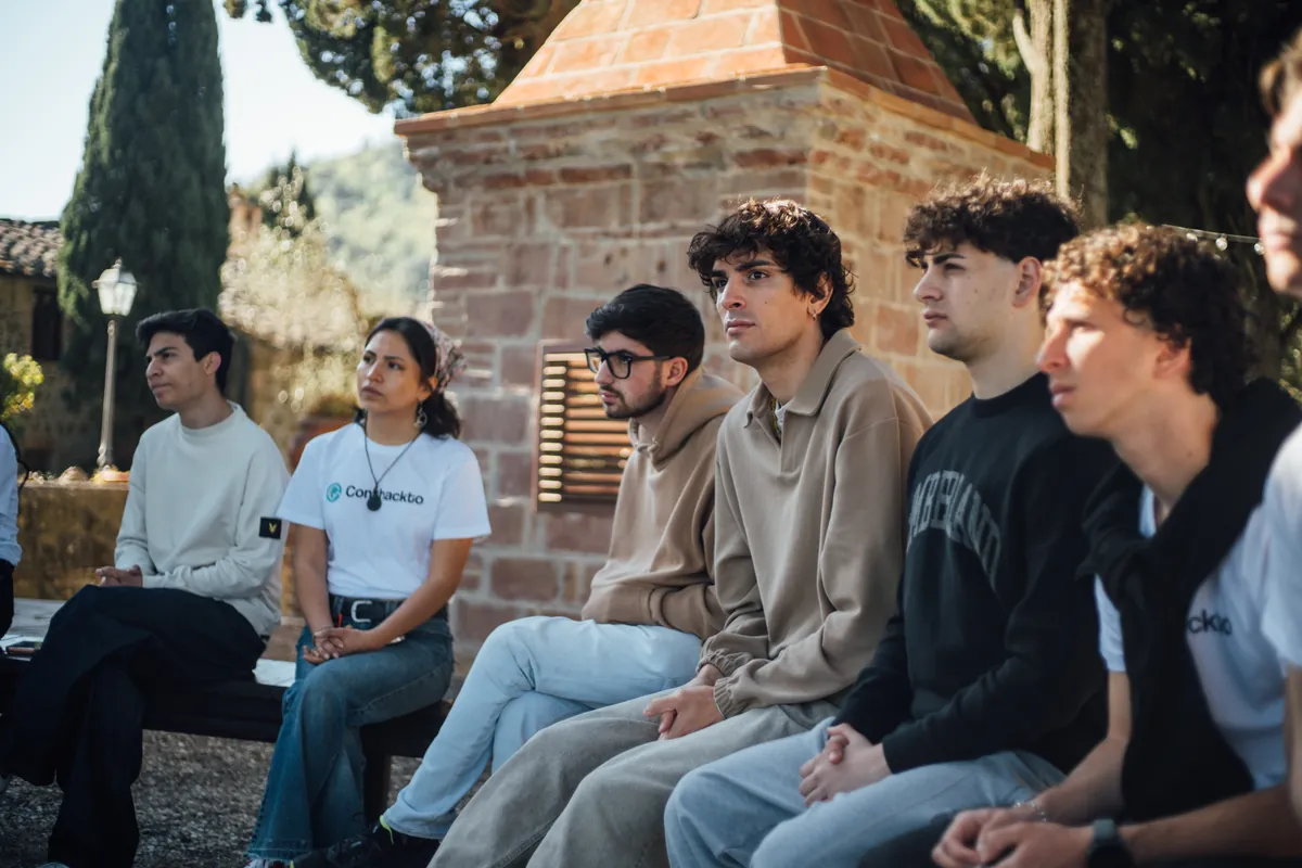 Giovani ascoltano una presentazione durante un incontro Conthackto
